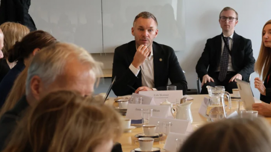 Personer runt ett bord med civilminister Erik Slottner i fokus